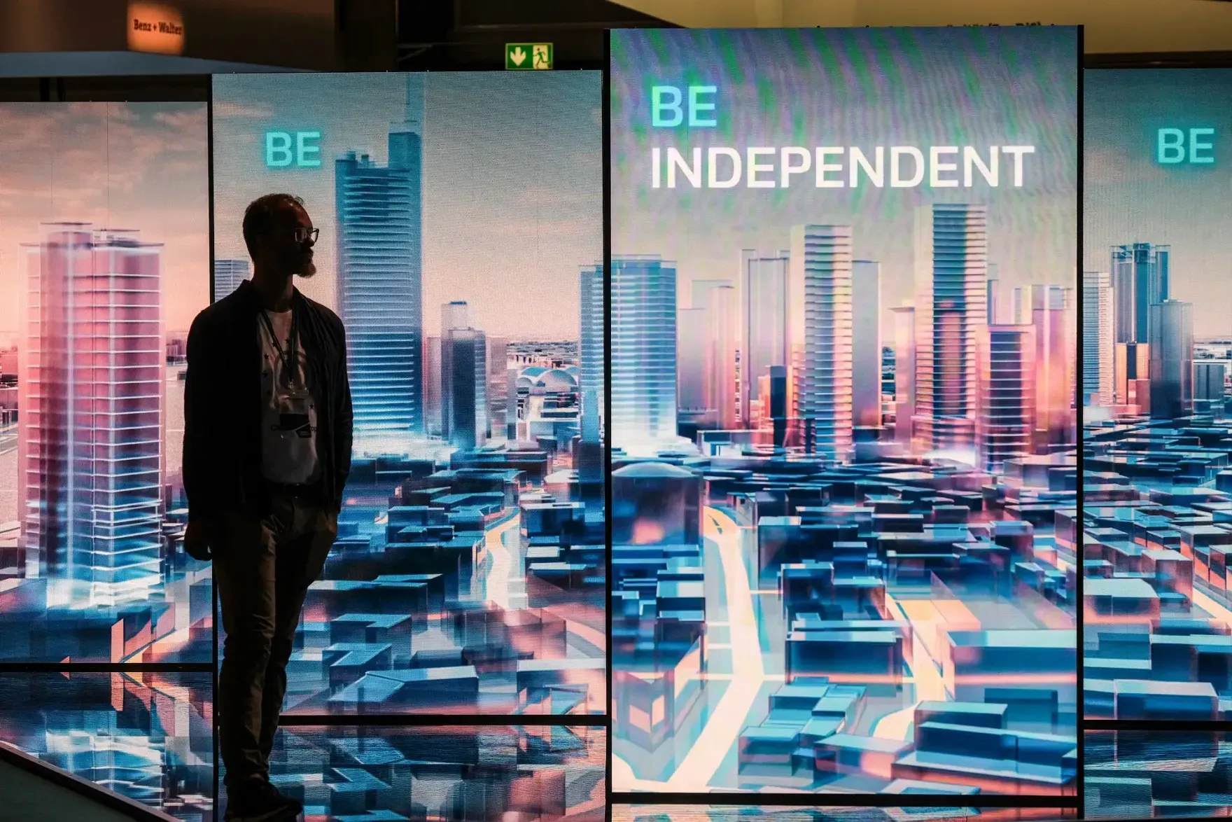 Visitor in front of large screens showing the words “Be independent” at the Smart Country Convention 2026